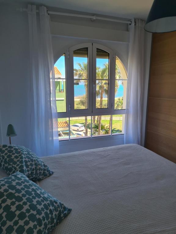 a bedroom with a bed and a large window at Cozy Beach Apartment in Málaga