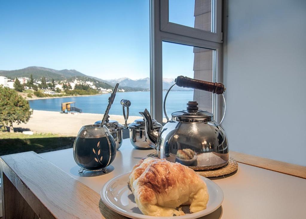 a table with a plate of bread and a tea kettle at AMANCAY DEL LAGO - Apartamento a Orillas del Lago in San Carlos de Bariloche
