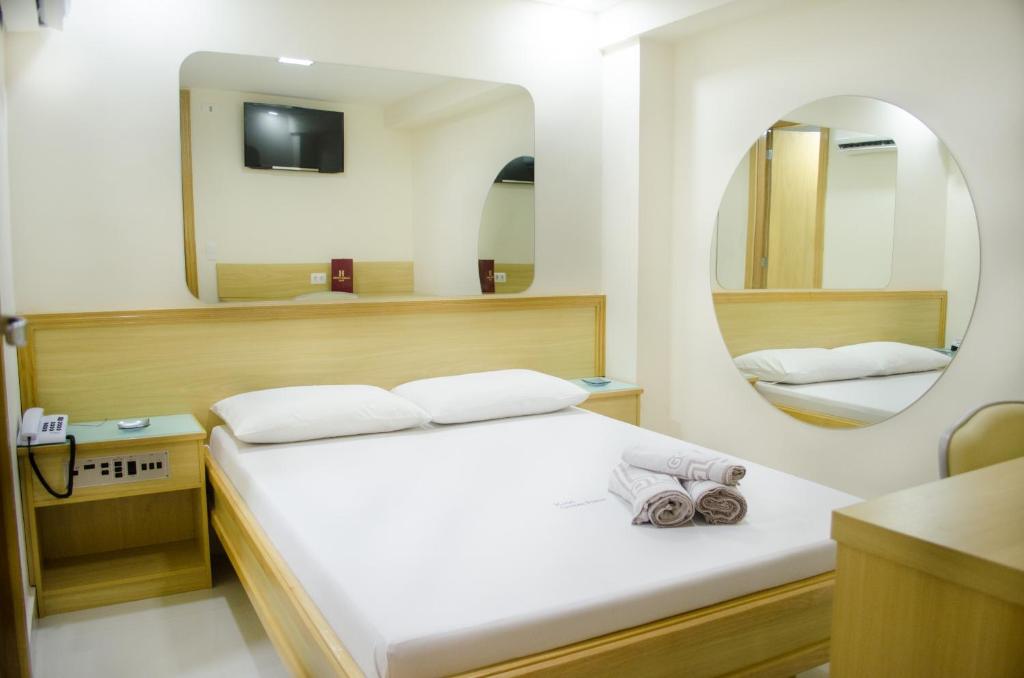 um quarto com uma cama grande e um espelho em Hotel Gomes Freire (Adult Only) no Rio de Janeiro