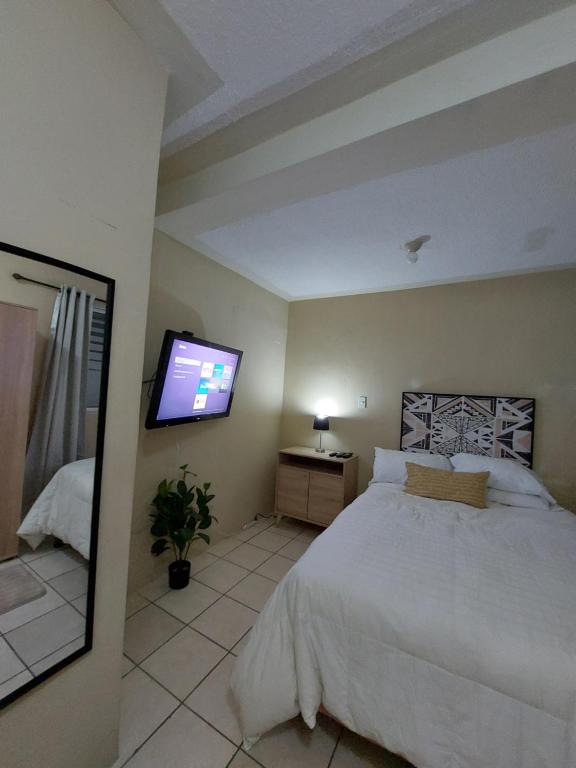 a bedroom with a bed and a flat screen tv at Habitación Privada en RESIDENCIAL Villa de Las Hadas in Tegucigalpa