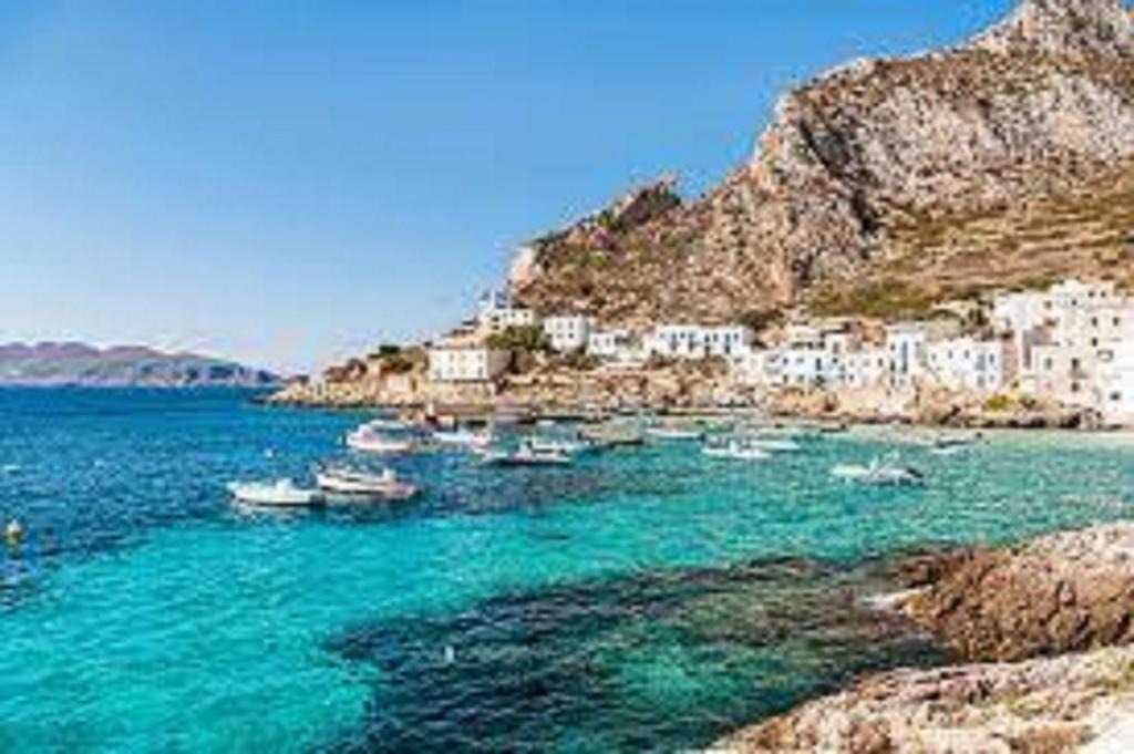 a group of boats in the water near a mountain at casetta in centro paese a 2 passi dalla piazza Matrice in Favignana