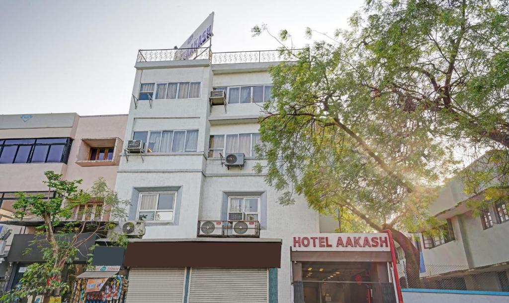 een hoog wit gebouw met een hotelverdovingsbord erop bij Itsy By Treebo - Aakash, 100 Mts From Sardar Patel Stadium in Ahmedabad