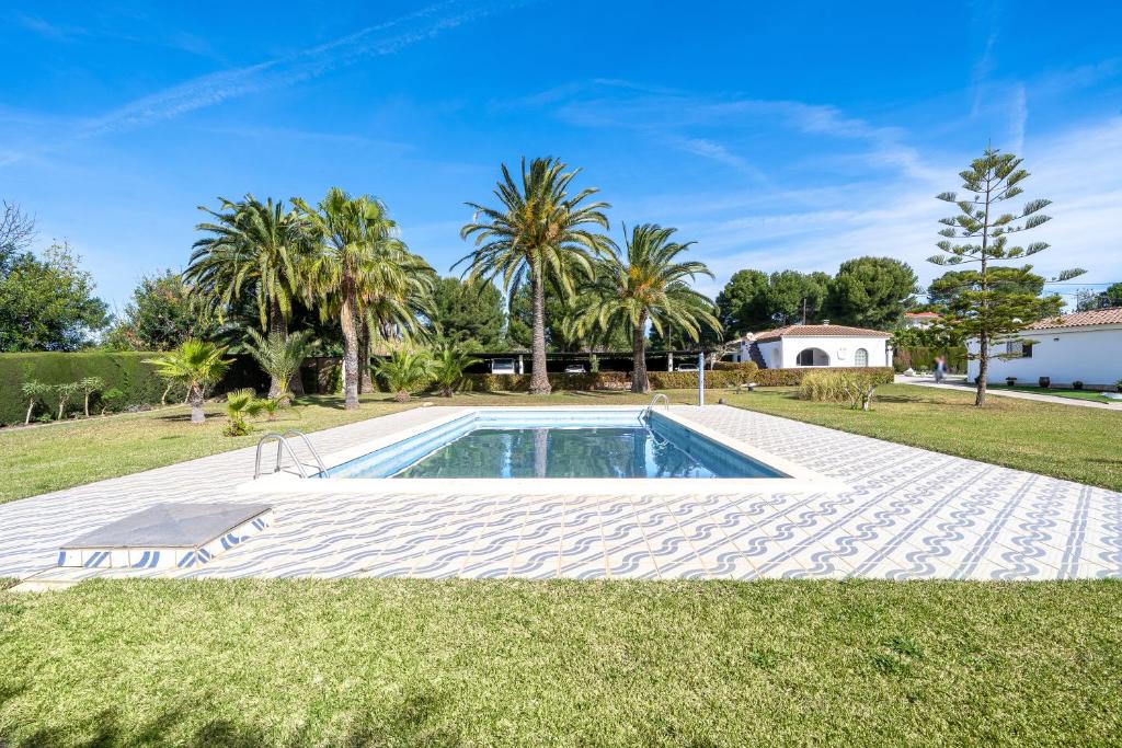 una piscina en un patio con palmeras en Paraiso en Cambrils Colibri Resort, en Cambrils