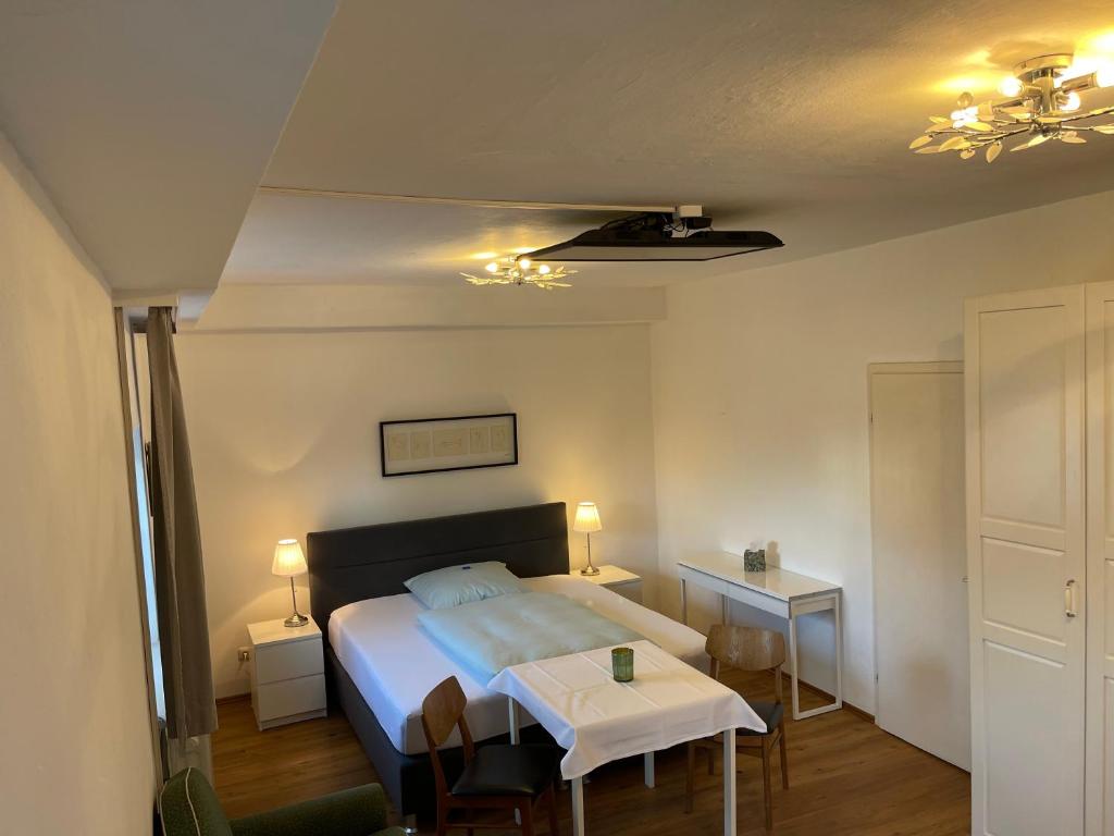 Un dormitorio con una cama y una mesa. en Ferienwohnung Einzimmerappartement, en Freilassing