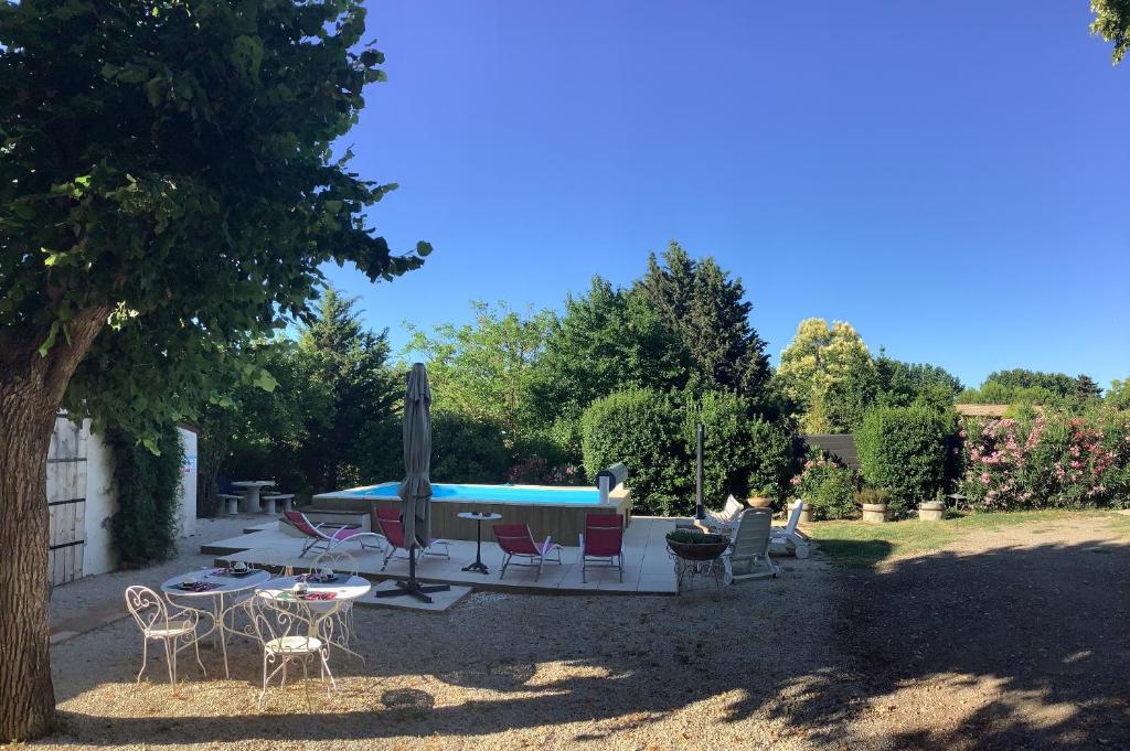 Canet d'AudeにあるChez Les Brocs B&Bの庭園内の椅子とスイミングプール
