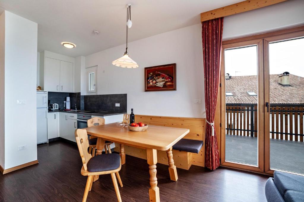 eine Küche und ein Esszimmer mit einem Holztisch in der Unterkunft Haus Hohenrain Ferienwohnung 4 in Schenna