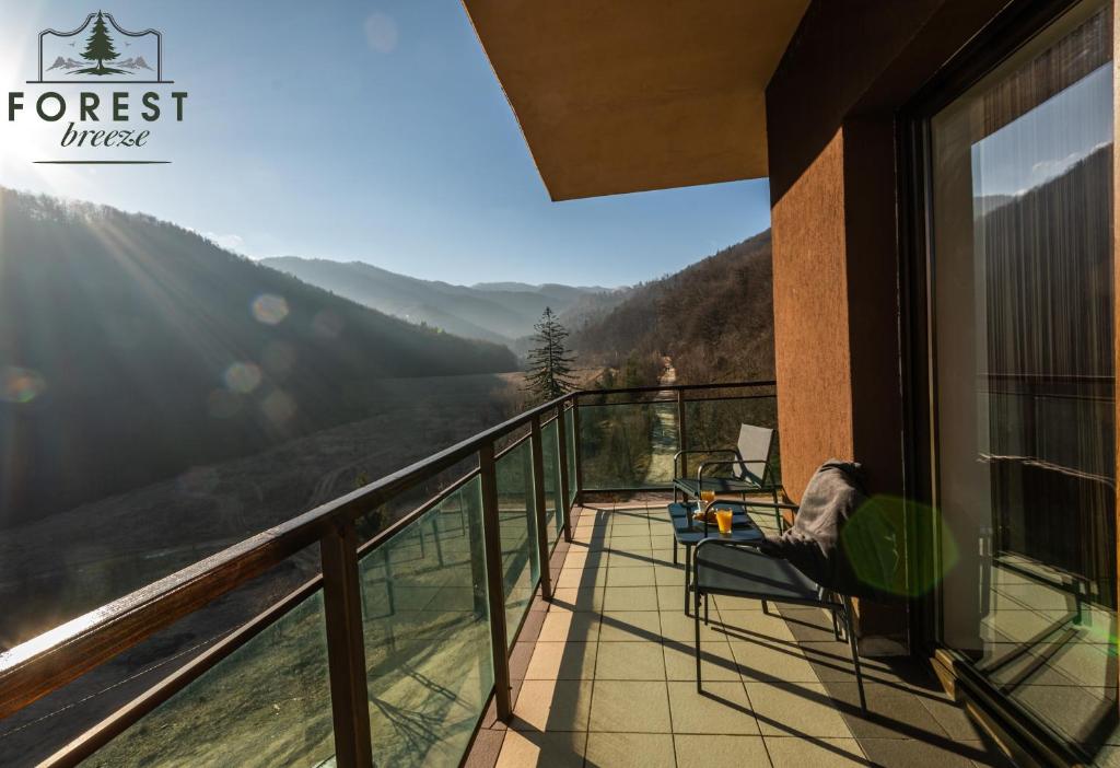 een balkon met stoelen en uitzicht op de bergen bij Forest Breeze ApartTerrace in Braşov
