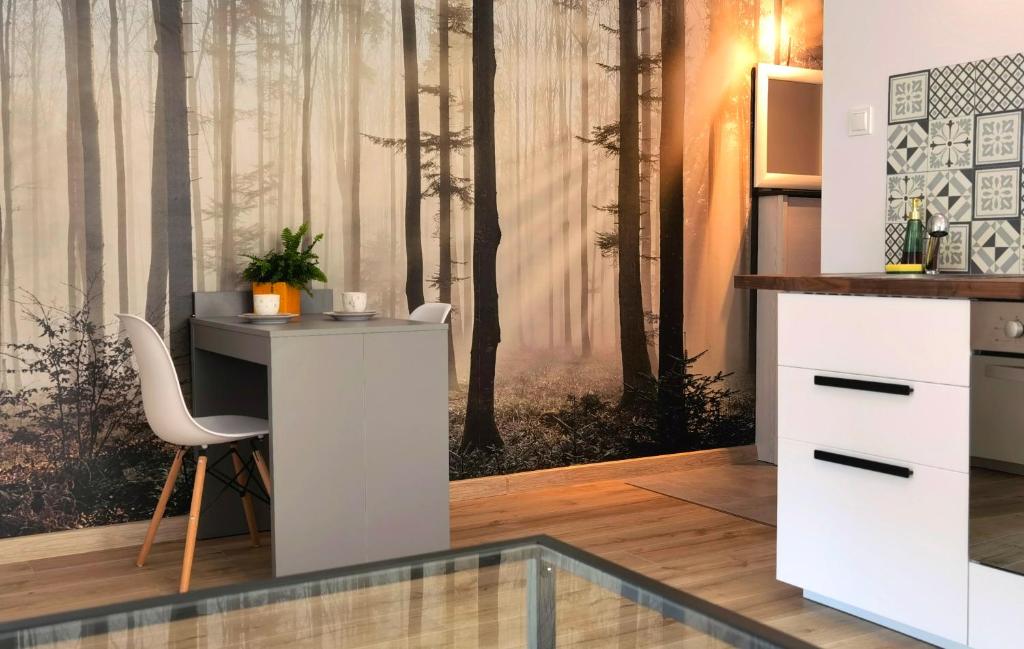 a desk in a room with a forest mural at Apartament Sosnowa in Puławy