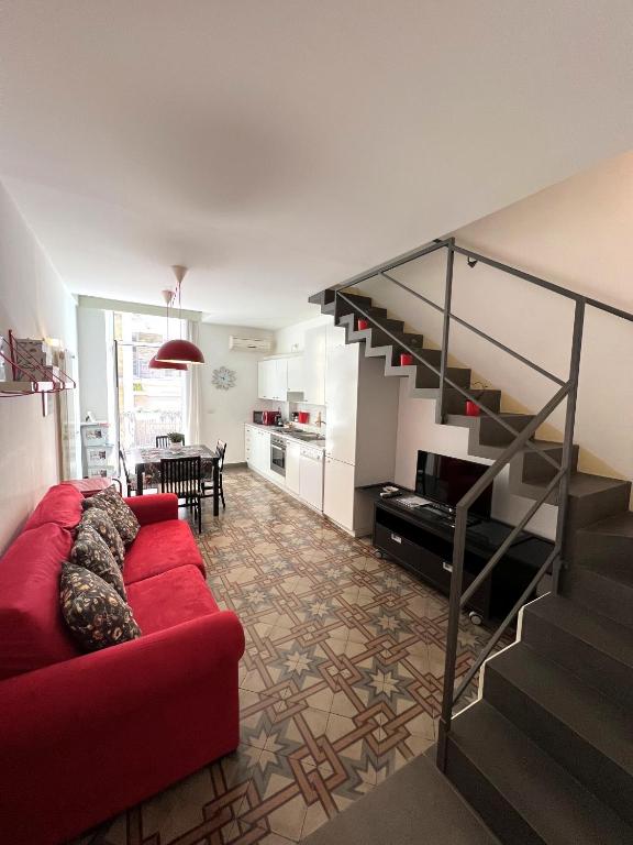 salon z czerwoną kanapą i schodami w obiekcie Bienvenue 3 w mieście Bari