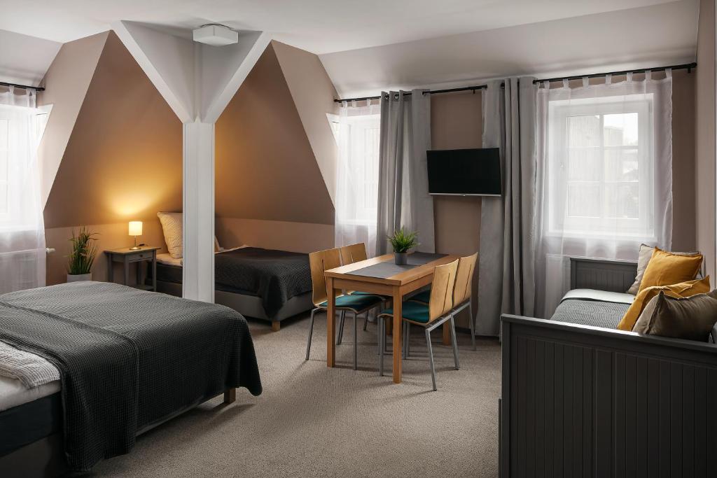Pokój hotelowy z łóżkiem, biurkiem i stołem w obiekcie Apartmán - Dům Českého Švýcarska w mieście Krásná Lípa