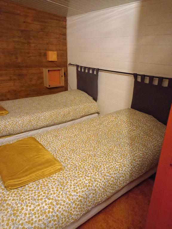 two beds sitting next to each other in a room at Bungalow la Bohémienne in Oissel