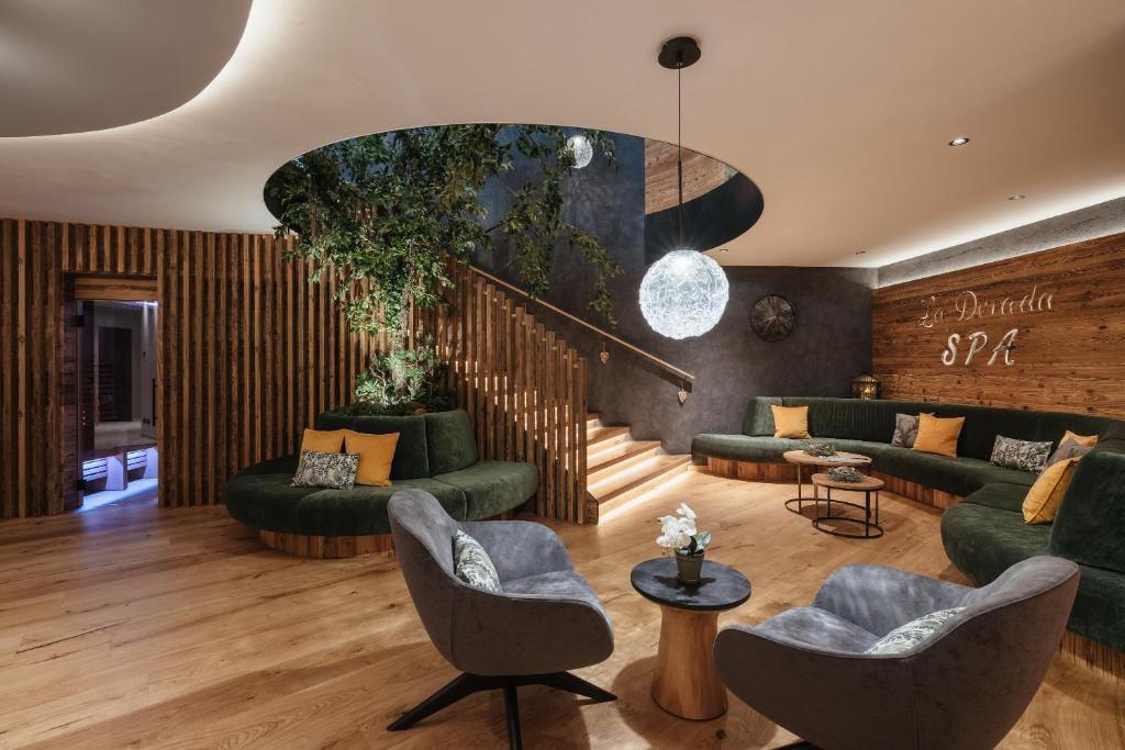 una sala de estar con muebles verdes y una escalera en Garnì La Dorada, en Colfosco