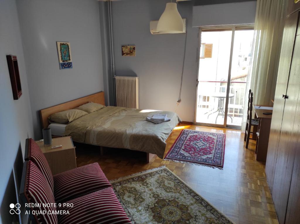 a small bedroom with a bed and a living room at Square 2 in Komotini