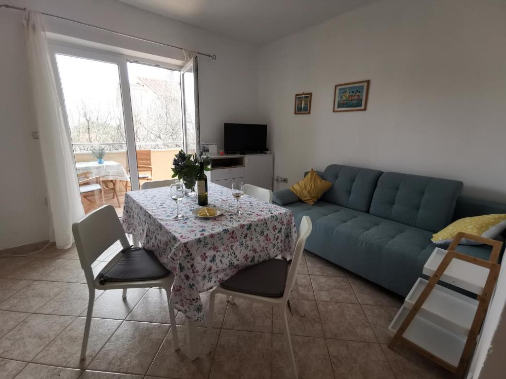 salon ze stołem i niebieską kanapą w obiekcie Apartment Zoanda w mieście Premantura