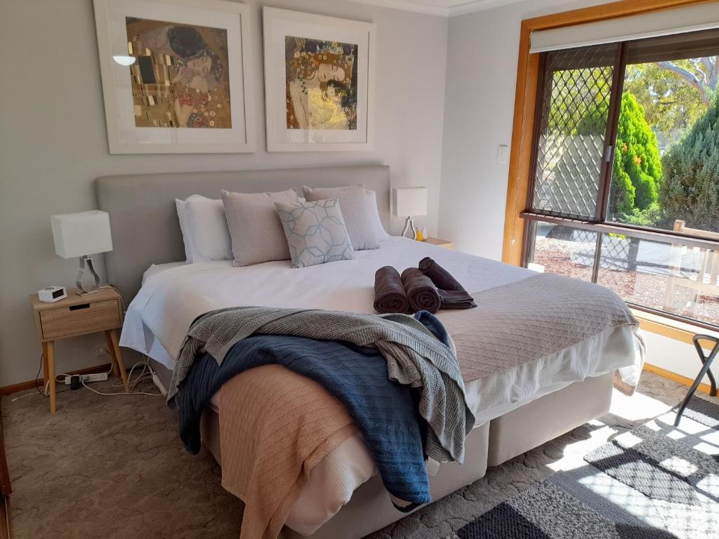 a bedroom with a large white bed with a window at 3 Pears on the Park McLaren Vale in McLaren Vale