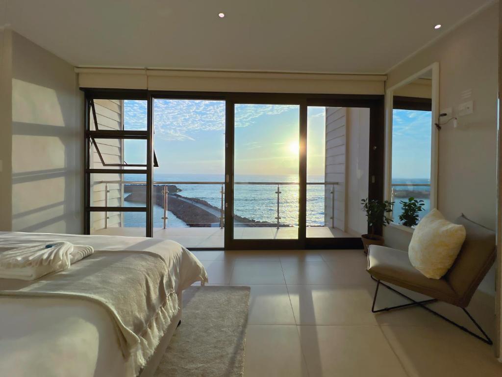 a bedroom with a bed and a view of the ocean at Seafront Condo at The Pier 17 in Swakopmund
