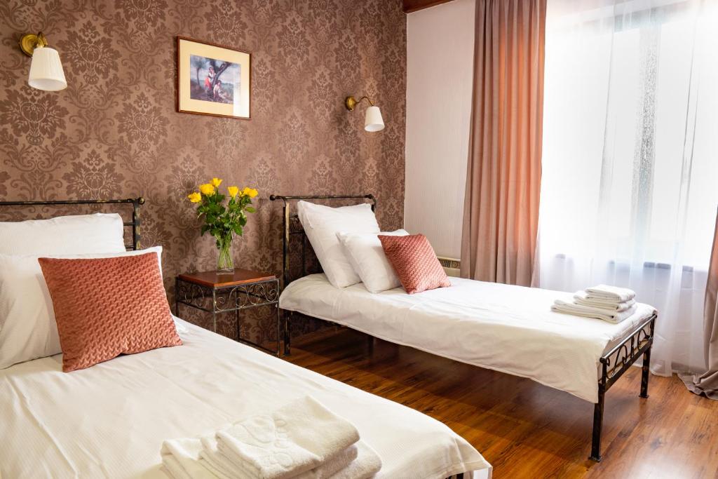 a hotel room with two beds and a vase of flowers at Rancho in Mała Nieszawka