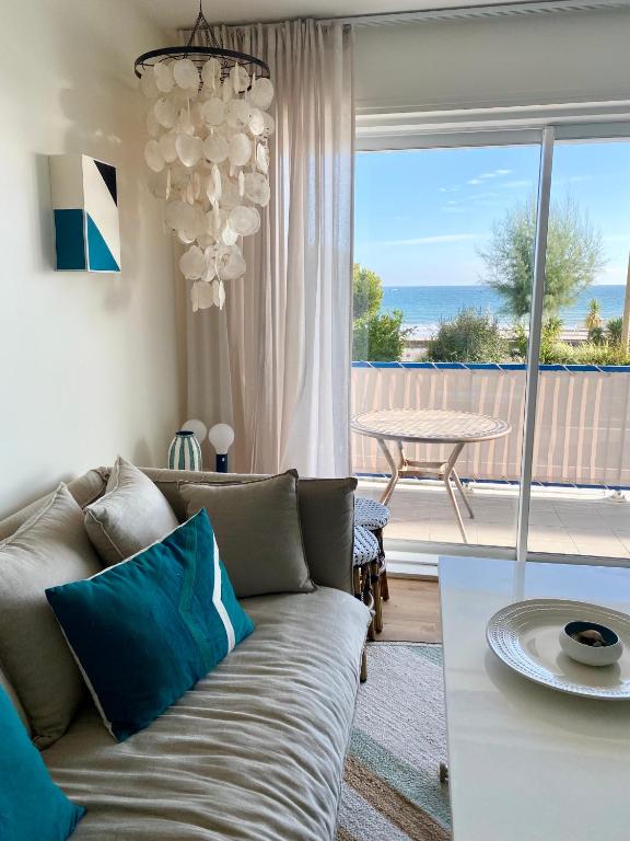 un salon avec un canapé et une vue sur l'océan dans l'établissement La cabine de Léontine, à La Baule