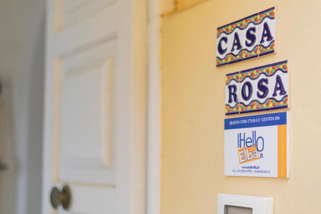 a sign on a wall next to a door at HelloElba Casa Rosa in Rio nellʼElba