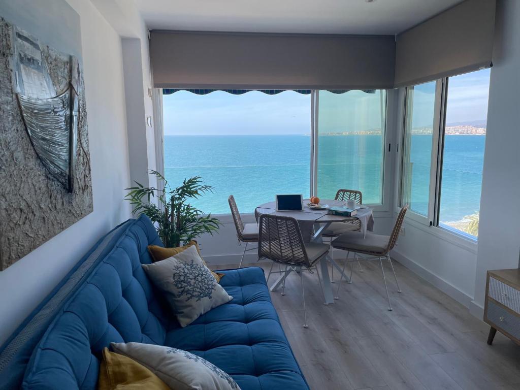 a living room with a blue couch and a table at Bow Sea Apartment in Algarrobo-Costa