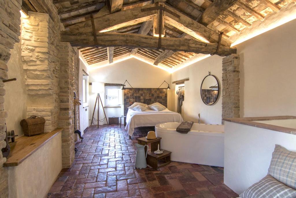 una camera con letto e vasca di Tuttomio Home&Breakfast Suite with whirlpool a Castiglion Fiorentino