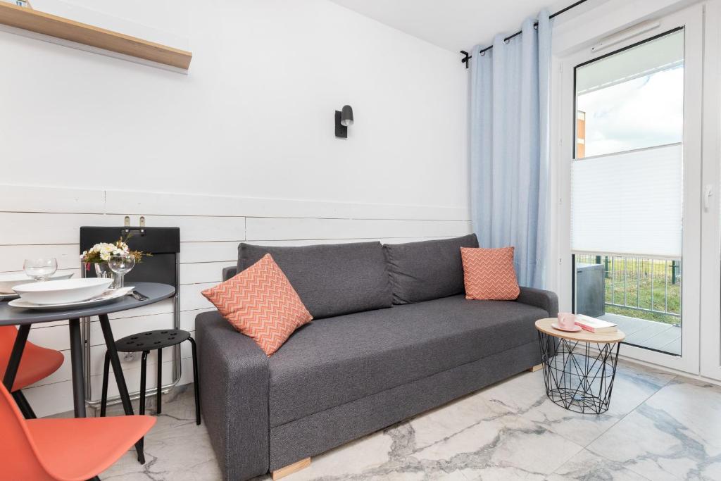 a living room with a couch and a table at Apartment Gdańsk Downtown by Renters in Gdańsk