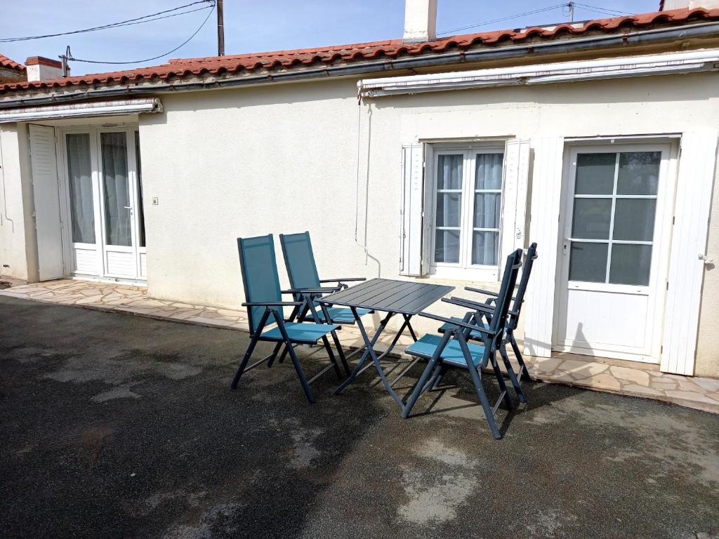 une table et des chaises assises à l'extérieur d'un bâtiment dans l'établissement GITE ENTRE TERRE ET MER GRAND STUDIO, à Mareuil-sur-Lay