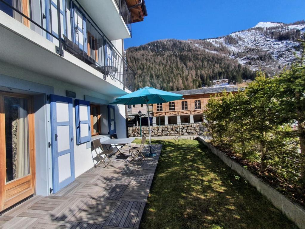 a balcony with a table and an umbrella at Garden apartment SPA&Pool in Vallorcine