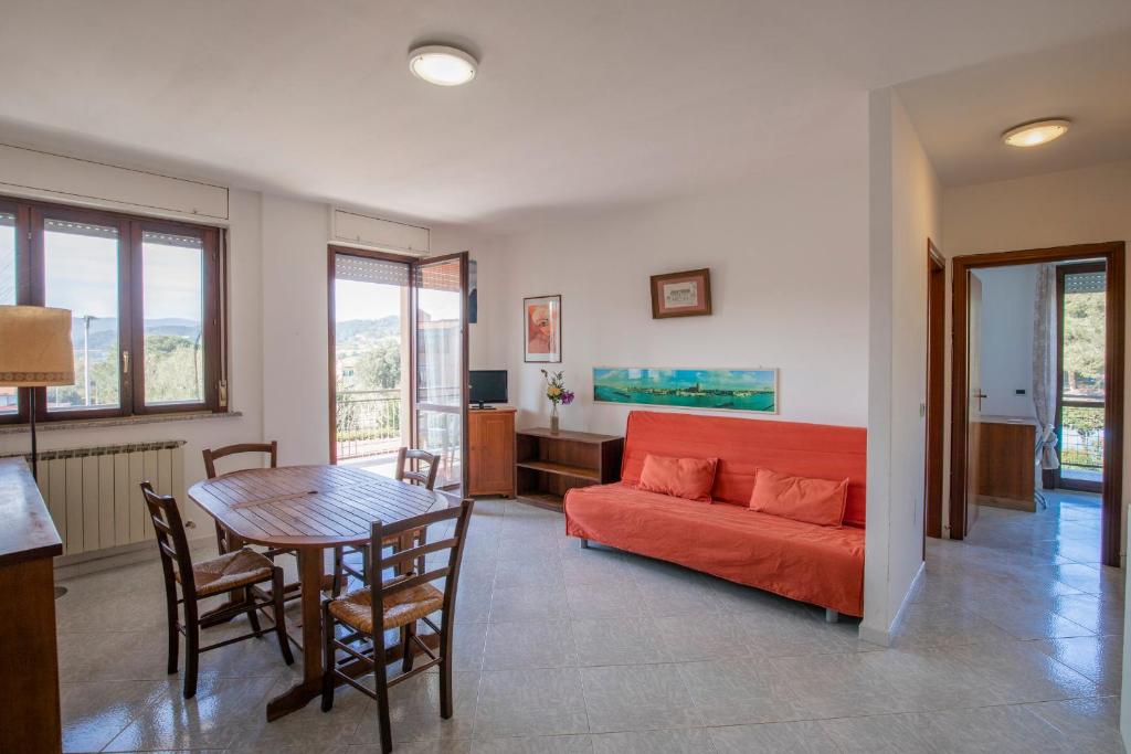 een woonkamer met een rode bank en een tafel bij HelloElba Appartamento Sottobomba in Portoferraio