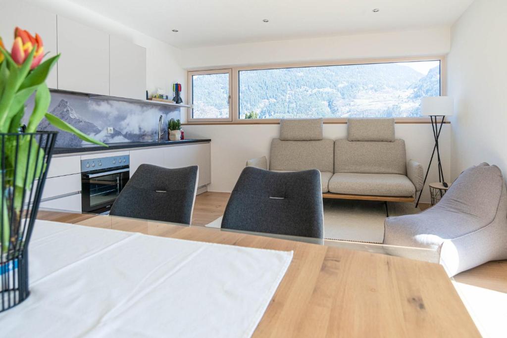 a living room with a couch and a table and chairs at My Mountain Destination in Sautens