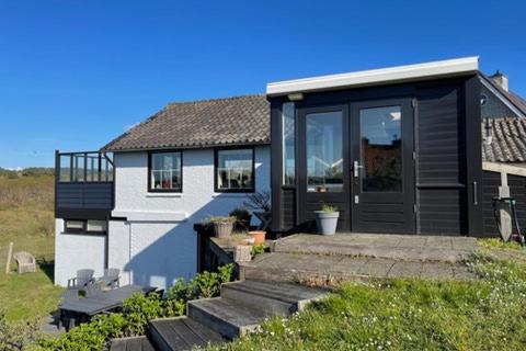 een huis met een zwarte deur en een trap bij Engelse Veld in Bergen aan Zee