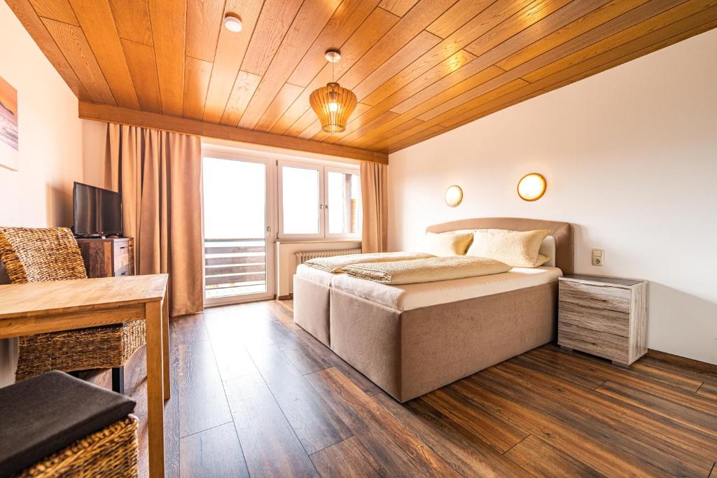 - une chambre avec un lit et un plafond en bois dans l'établissement Steinbühler Hof - Stressfrei am Lande, à Bad Kötzting