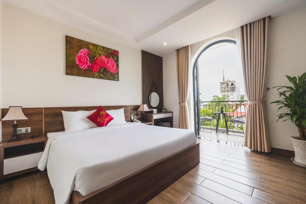 een slaapkamer met een groot bed en een groot raam bij City Center Rosa Hotel in Phu Quoc