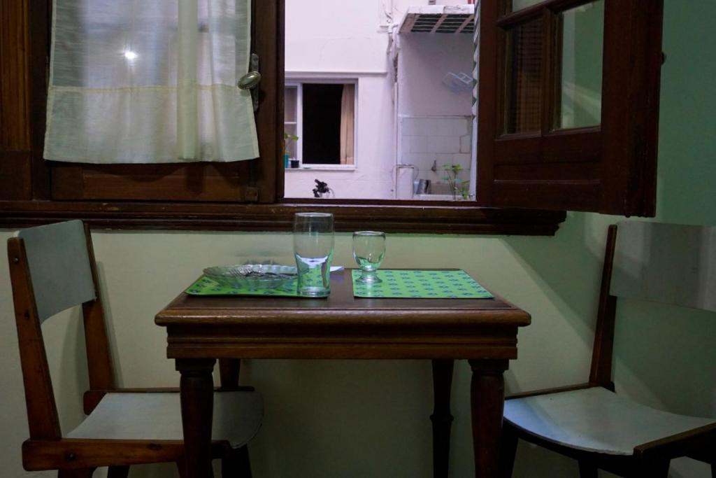 a wooden table with two glasses on top of it at Hotel Tango Club 2 in Buenos Aires
