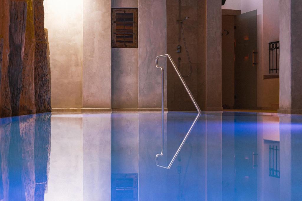 a swimming pool with a hand rail in the water at Himmlhof in Sankt Anton am Arlberg