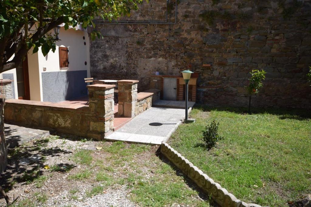 dziedziniec z ceglaną ścianą i światłem ulicznym w obiekcie Giardino dei Segreti w mieście Scarlino