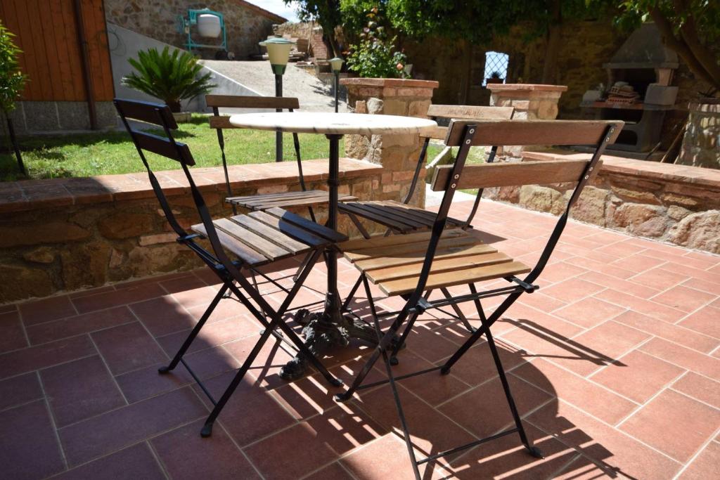 dwa krzesła i stół na patio w obiekcie Giardino dei Segreti w mieście Scarlino