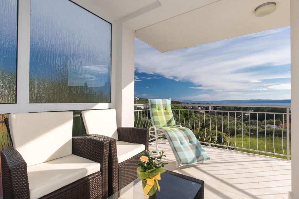 d'un balcon avec des chaises et une vue sur l'océan. dans l'établissement Apartment Salvagno, à Punat