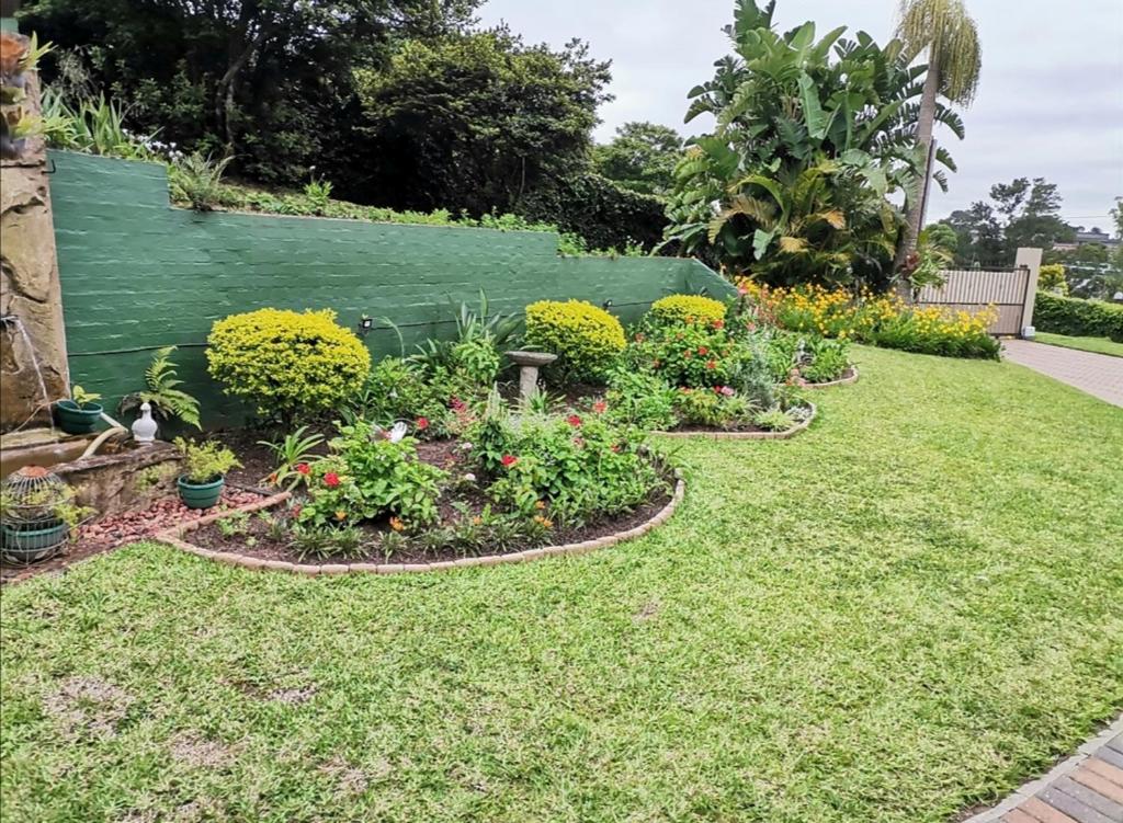 a garden with flowers and plants in a yard at The calm corner in Pinetown