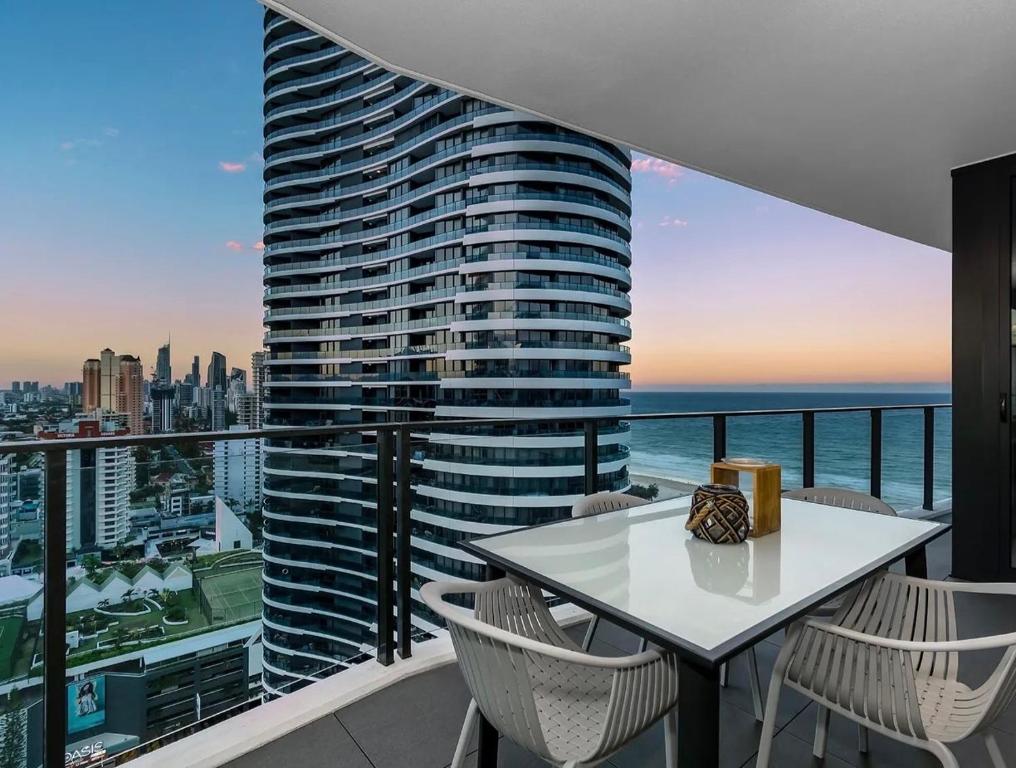 a balcony with a table and chairs and a tall building at Koko luxury apartment in Broadbeach in Gold Coast