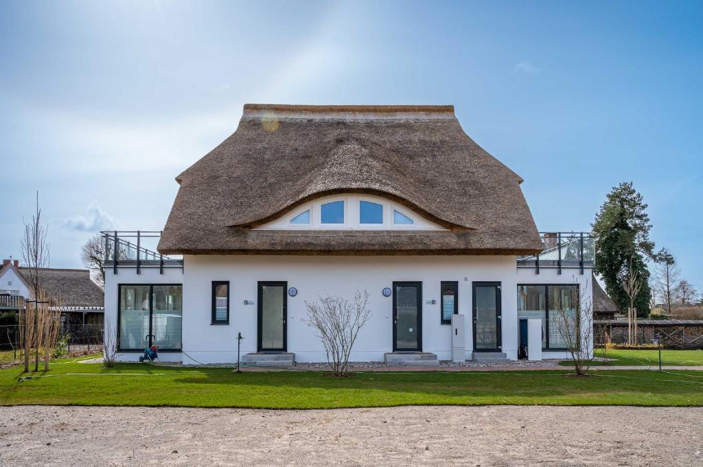 a white house with a thatched roof at Reethus Reethus 3 in Born