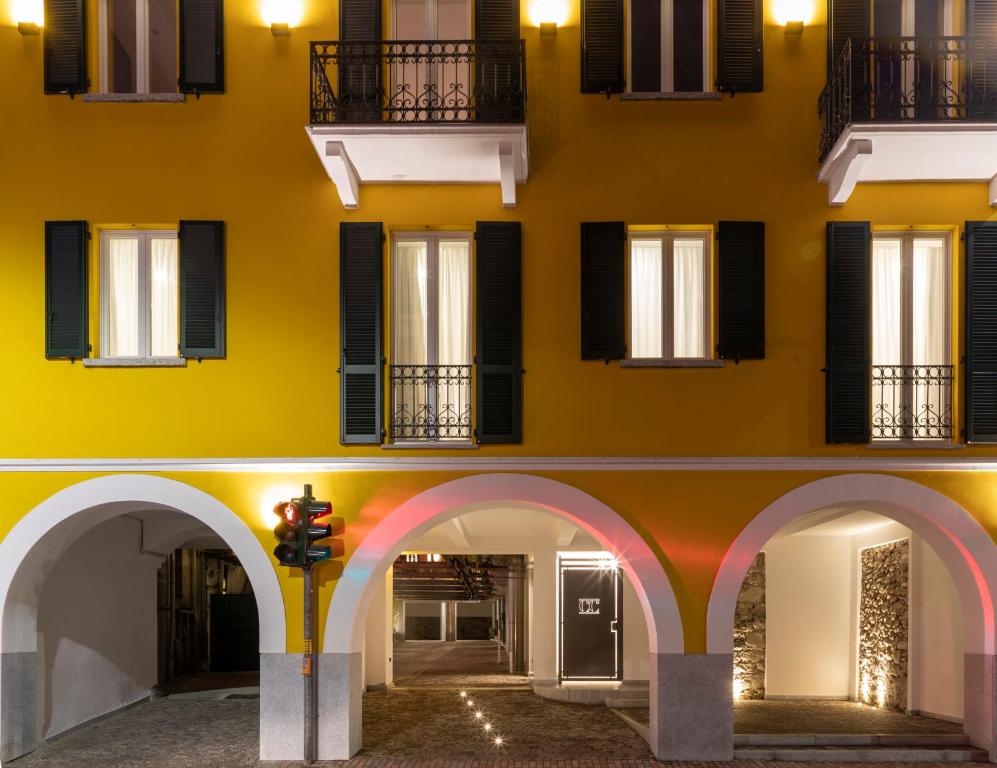 a yellow building with arches and windows at Residence Casa Coppa Appartamento Jasmine in Omegna