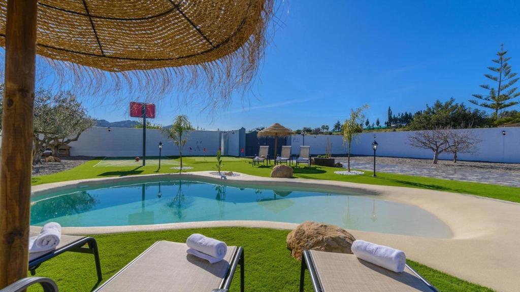 a swimming pool in a yard with two tables and chairs at Casa Serrano Cártama by Ruralidays in Cártama
