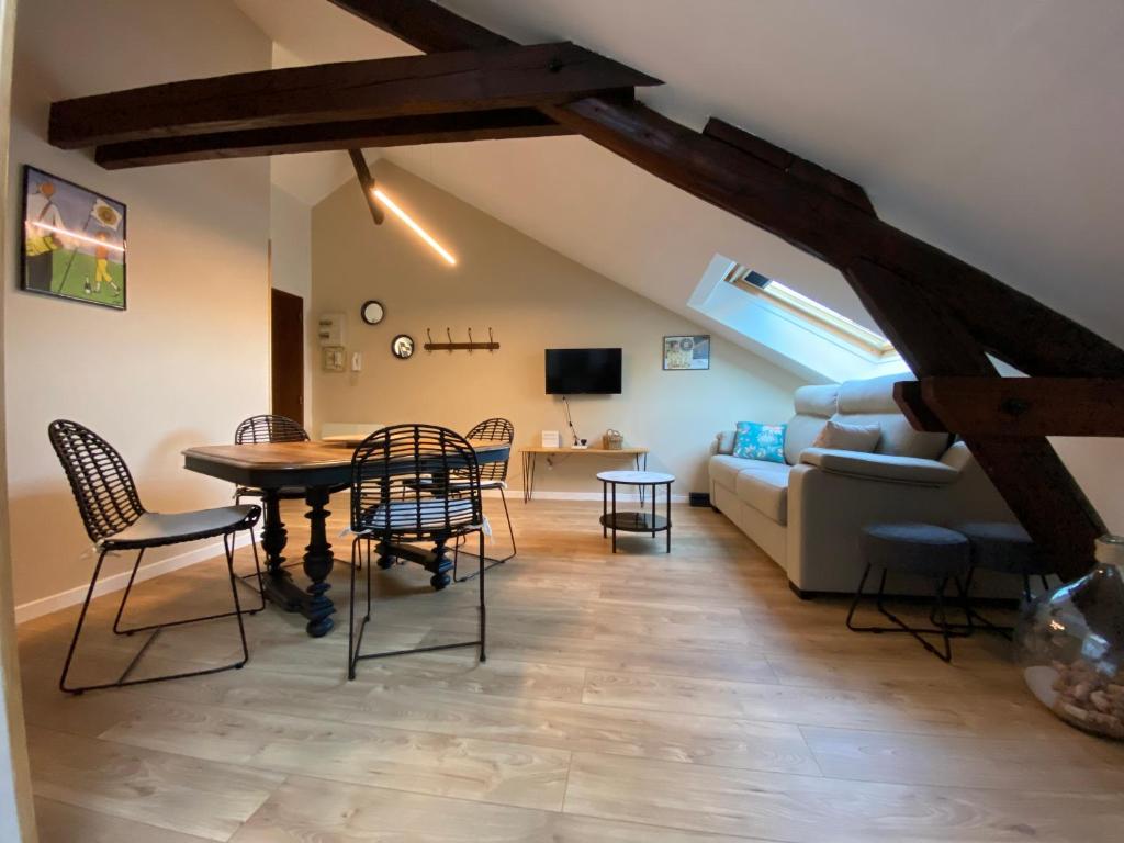 uma sala de estar com uma mesa e cadeiras e um sofá em Cocon en Champagne em Épernay