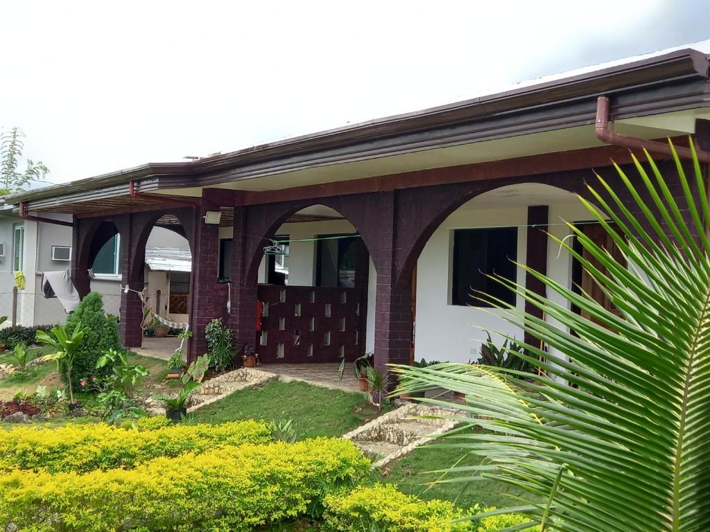 a house with an arched entry way with a porch at Teresa house Rental Villa Teresa Philippines in Moalboal