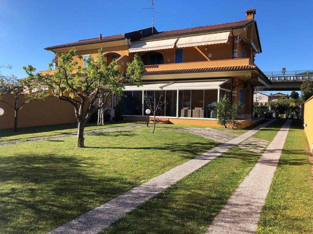 a house with a tree in the front yard at Casa Vacanze Sunflower in Carrara