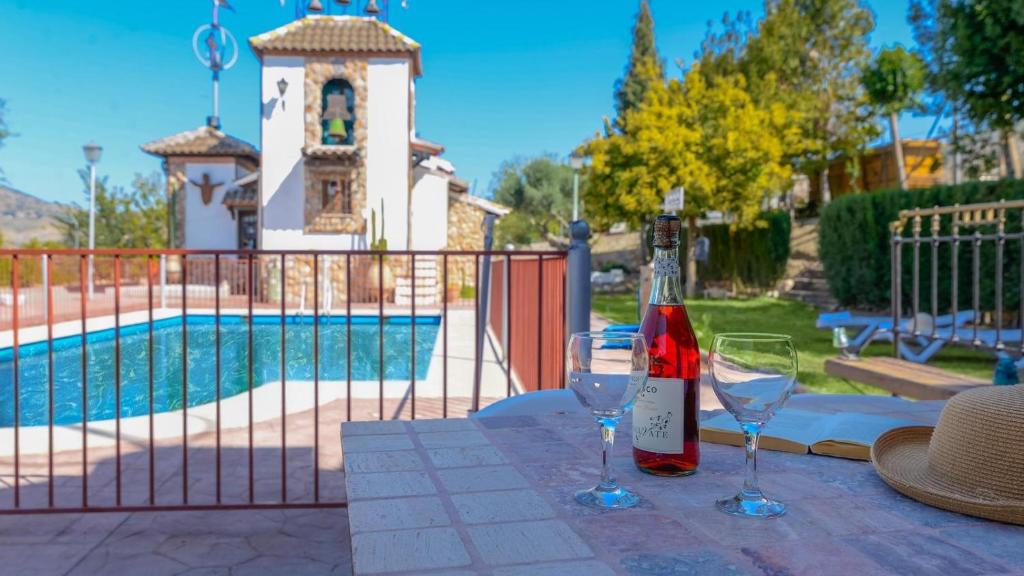 a bottle of wine and two glasses on a table at Casa El Secanillo Loja by Ruralidays in Loja