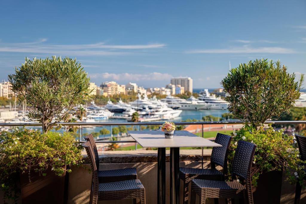 a table and chairs on a balcony with a marina at Duquesa Suites Barcelona in Barcelona