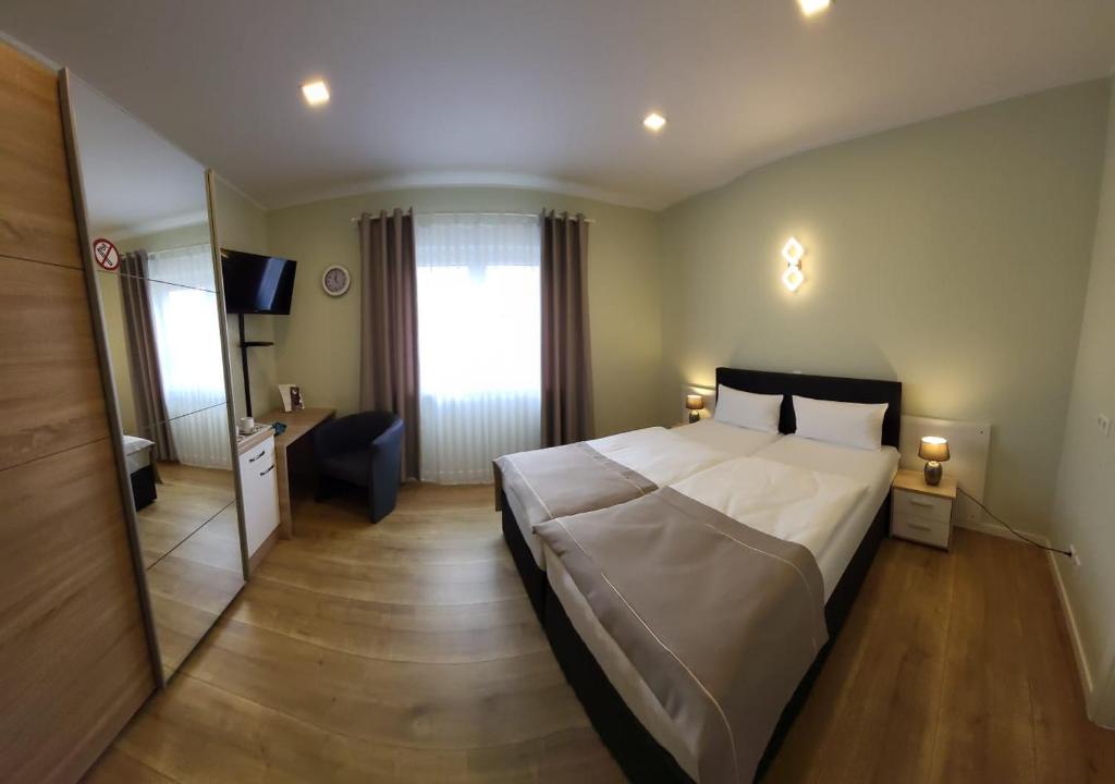 a hotel room with a large bed and a mirror at Lutz Motel in Paderborn