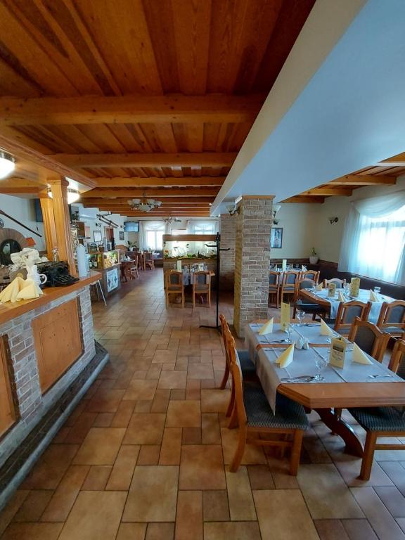 um restaurante com mesas e cadeiras e uma lareira em Szepi Fogadó Szendehely em Szendehely
